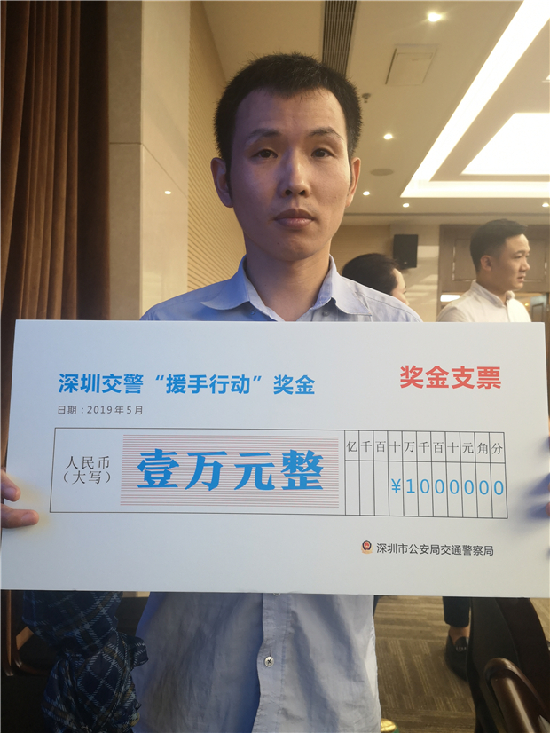 在新闻通气会现场,深圳交警为两位获得1万元奖励的热心市民代表颁发了