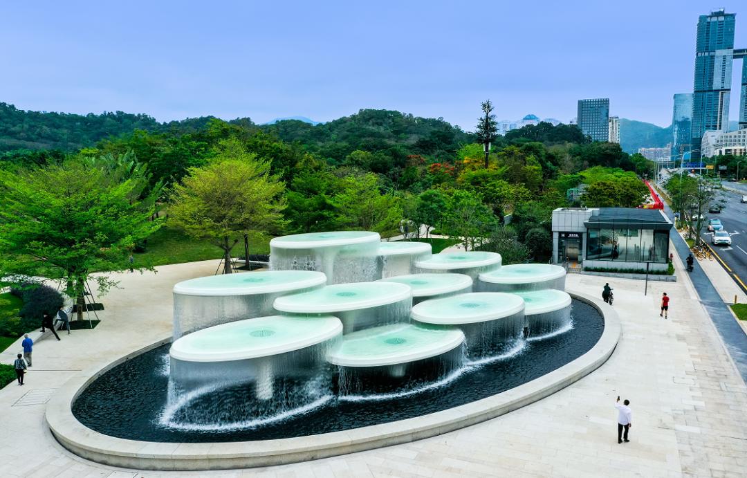 市民三三两两地在水景旁休息娱乐,伴着水声翩翩起舞.