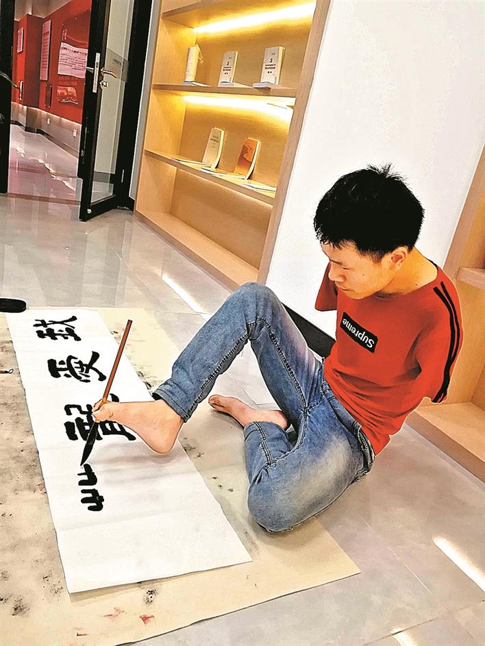 也许你曾经遇到过这个无臂年轻人正在摆摊写字